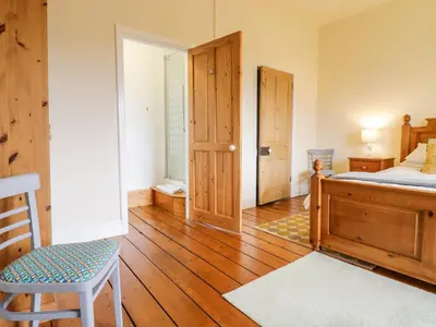 a bedroom with a bed and a wooden floor at Groes Lwyd in Gwyddelwern
