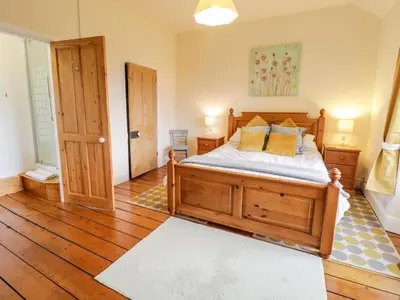 a bedroom with a wooden bed and wooden floors at Groes Lwyd in Gwyddelwern