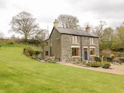 a stone house with a garden in front of it at Groes Lwyd in Gwyddelwern