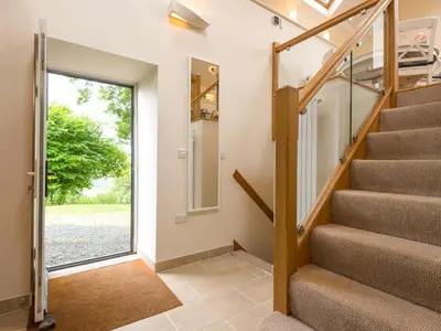 a staircase in a house with a glass door at Bishop's Castle Barn in Bishops Castle