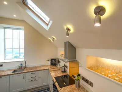 a kitchen with a sink and a counter with wine glasses at Bishop's Castle Barn in Bishops Castle
