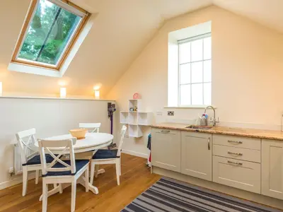 a kitchen with a table and chairs and a window at Bishop's Castle Barn in Bishops Castle