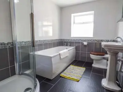 a bathroom with a tub and a toilet and a sink at Maerdy Cottage in Bettws Gwerfil Goch