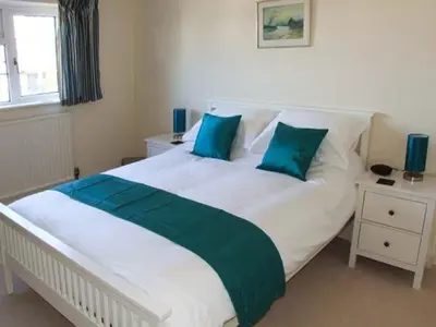 a bedroom with a large white bed with blue pillows at Harris House in Ludlow