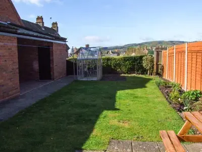 a backyard with a green yard with a fence at Harris House in Ludlow