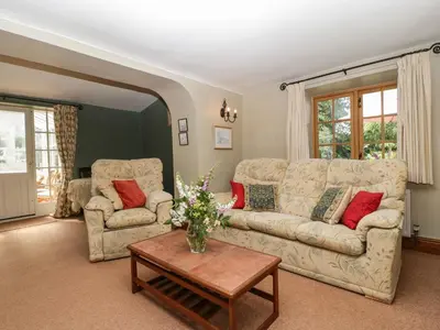 a living room with two couches and a table at Lower Court Byre in Kinsham