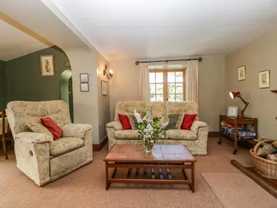 a living room with two couches and a coffee table at Lower Court Byre in Kinsham