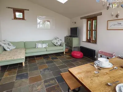 a living room with a green couch and a table at Gatehouse in Painscastle