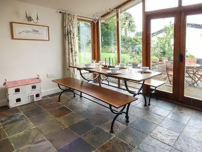 a living room with a table and a large window at Gatehouse in Painscastle