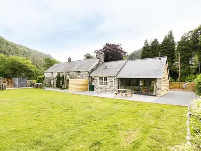 an exterior view of a house with a large yard at Hen Gelligemlyn - The Annexe in Llanfachreth