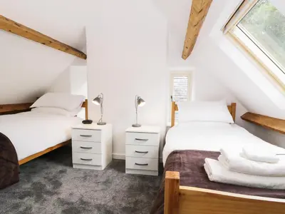 two beds in a attic bedroom with white walls at Hen Gelligemlyn - The Annexe in Llanfachreth