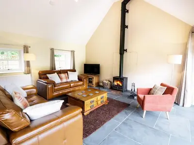a living room with leather furniture and a fireplace at Hen Gelligemlyn - The Annexe in Llanfachreth