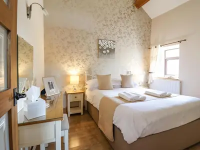a bedroom with a bed and a desk and a window at Bwthyn Ty Newydd in Pont Dolanog