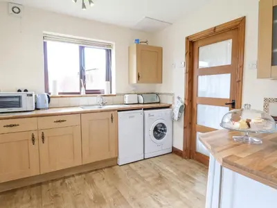 a kitchen with a washer and dryer in it at Bwthyn Ty Newydd in Pont Dolanog