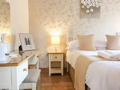 a bedroom with two beds and a desk with a computer at Bwthyn Ty Newydd in Pont Dolanog
