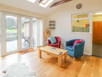 a living room with two chairs and a coffee table at Trederwen in Rhayader