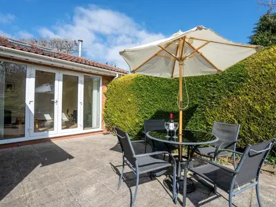 a table and chairs with an umbrella on a patio at Trederwen in Rhayader