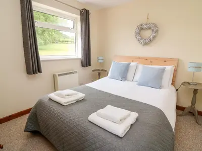 a bedroom with a large bed with towels on it at Red Kite Cottage in Llandrindod Wells
