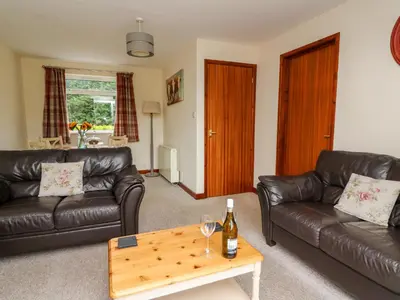 a living room with two leather couches and a coffee table at Red Kite Cottage in Llandrindod Wells