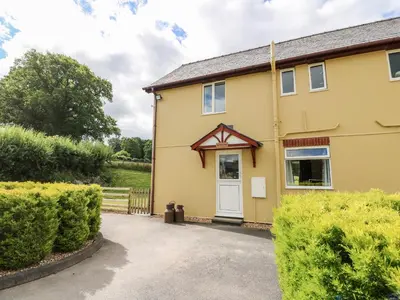 a house with a driveway in front of it at Red Kite Cottage in Llandrindod Wells