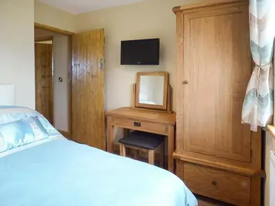 a bedroom with a bed and a dresser with a mirror at Valley View Lodge in Trelystan
