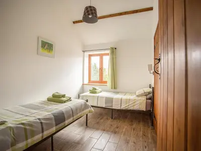 two beds in a room with a window at 2 Beacon View Barn in Felindre