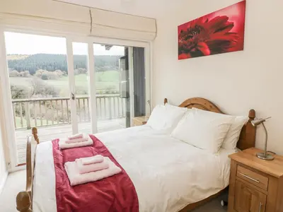 a bedroom with a bed and a large window at Middle Hivron in Bleddfa