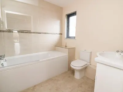 a bathroom with a tub and a toilet and a sink at Caban Nant Ddu in Nantmel