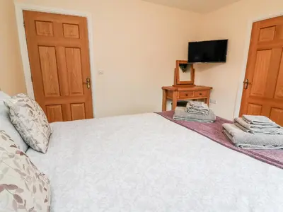 a bedroom with a bed with a television on a table at Caban Nant Ddu in Nantmel