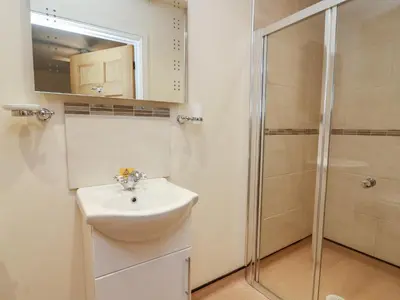 a bathroom with a sink and a shower at Caban Nant Ddu in Nantmel