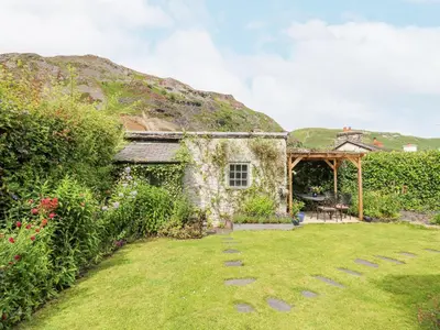 an old stone house with a grass yard at Bodywen in Llangynog