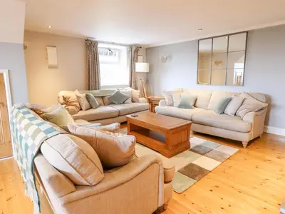 a living room with two couches and a table at Is Y Deri in Harlech