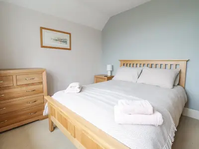 a bedroom with a bed with two towels on it at Is Y Deri in Harlech