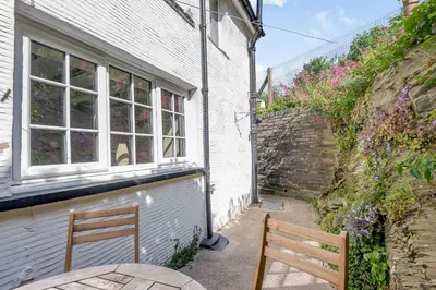 a wooden bench sitting in front of a building at Kynaston Cottage in Aberdyfi