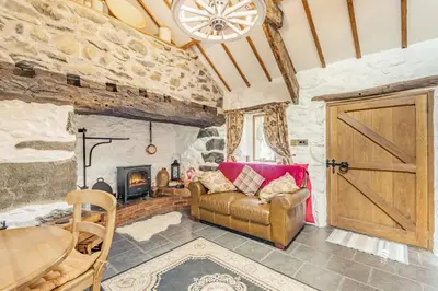 a living room with a couch and a fireplace at Y Becws in Llanbedr