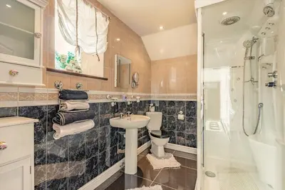 a bathroom with a toilet and a sink and a shower at Y Becws in Llanbedr