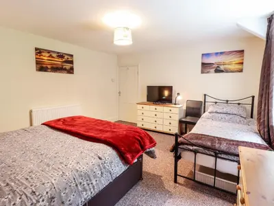 a bedroom with two beds and a television at 2 Isygraig in Corris