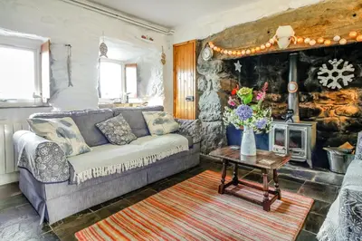a living room with a couch and a fireplace at Hwylfa'r Groes in Dyffryn