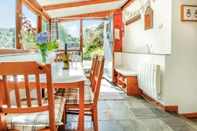 a kitchen and dining room with a table and chairs at Hwylfa'r Groes in Dyffryn