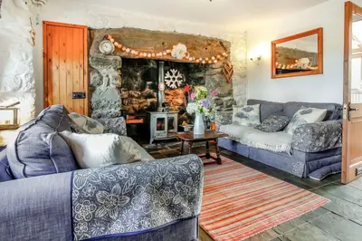a living room with two couches and a fireplace at Hwylfa'r Groes in Dyffryn