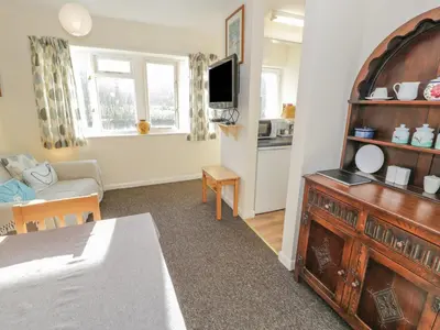 a living room with a television and a room with a couch at Bryn Melyn Artist's Cottage in Llanelltyd
