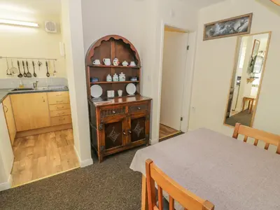 a kitchen with a table and a mirror at Bryn Melyn Artist's Cottage in Llanelltyd