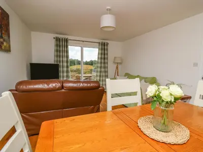 a living room with a table and a couch at Foxes Meadow in Llandrindod Wells