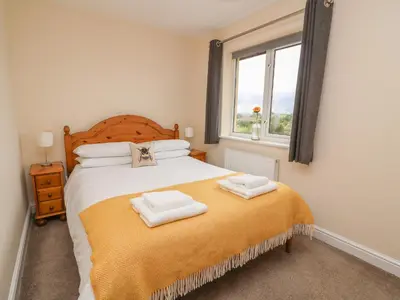a bedroom with a bed with two towels on it at Pheasant Wood in Llandrindod Wells