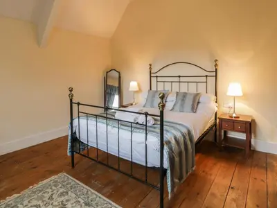 a bedroom with a bed and a wooden floor at The Mill House in Carrog