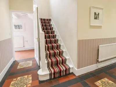 a spiral staircase in a hallway with a striped carpet at The Mill House in Carrog