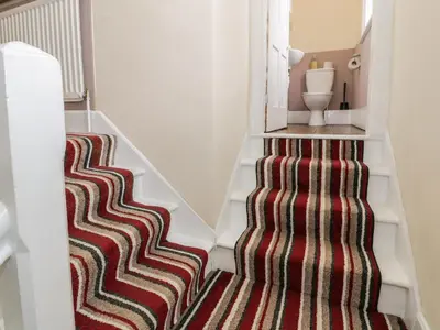 a carpeted staircase with a red and brown rug at The Mill House in Carrog