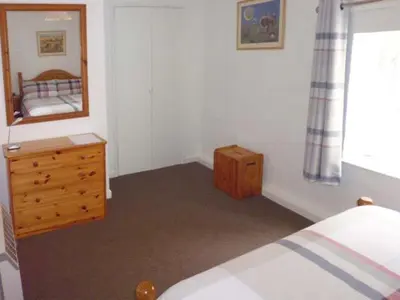 a bedroom with a bed and a dresser and a mirror at Harley Apartment in Bishops Castle