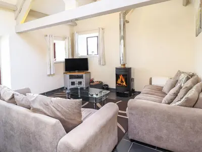 a living room with two couches and a fireplace at Beudy Bach Barn in Llanuwchllyn