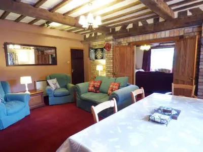 a living room with blue chairs and a table at Arllen Fawr in Pen-y-bont-fawr